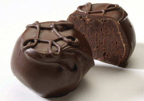 Two pieces of dark chocolate truffles with a raspberry purée filling, coated with a glazing chocolate on top.