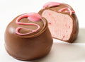 A chocolate truffle with a pink strawberry design on top, with a milk chocolate coating.