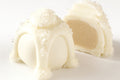 A photo showing two white chocolate truffles with a crystallized sugar topping on a white background.