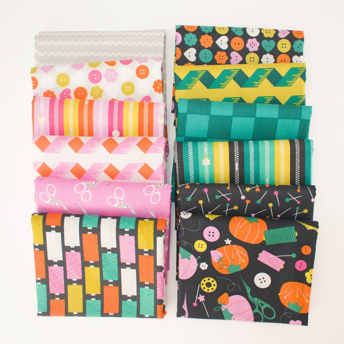 Twelve folded fabric swatches arranged in two columns of six on a plain white background. The fabrics feature various colorful patterns including stripes, checkers, and other whimsical sewing-themed illustrations like spools of thread, buttons, and scissors in bright colors.