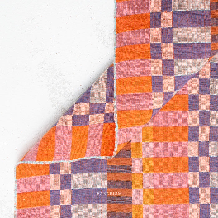 Checkered fabric with orange and purple pattern on a white background