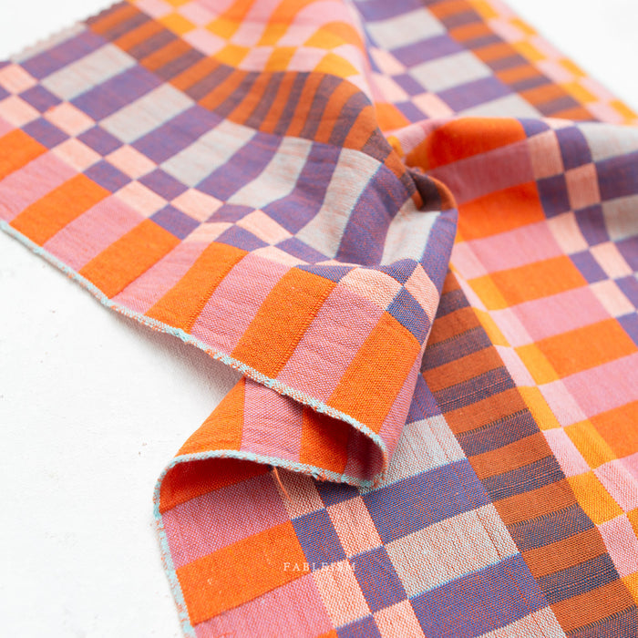 Checkered fabric with orange, pink, and purple pattern on a white background