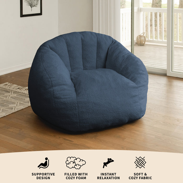 Blue bean bag chair in a room with wooden floor and large window #color_slate-blue-teddy-boucle
