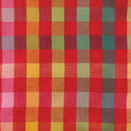 A close-up of a plaid fabric pattern with intersecting vertical and horizontal bands in red, pink, orange, yellow, green, and teal, showing a woven texture.
