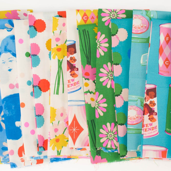 A fan-like arrangement of colorful patterned fabric with illustrations of a vintage inspired shopping at a market- with cans, telephones, dots, faces, and florals, in greens, pinks, off whites, and blues.