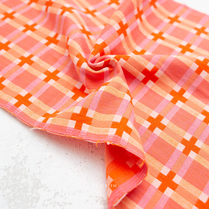 Close-up of orange and pink checkered fabric on a white background