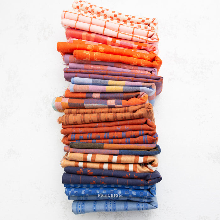 Stack of folded colorful fabric swatches on a white background