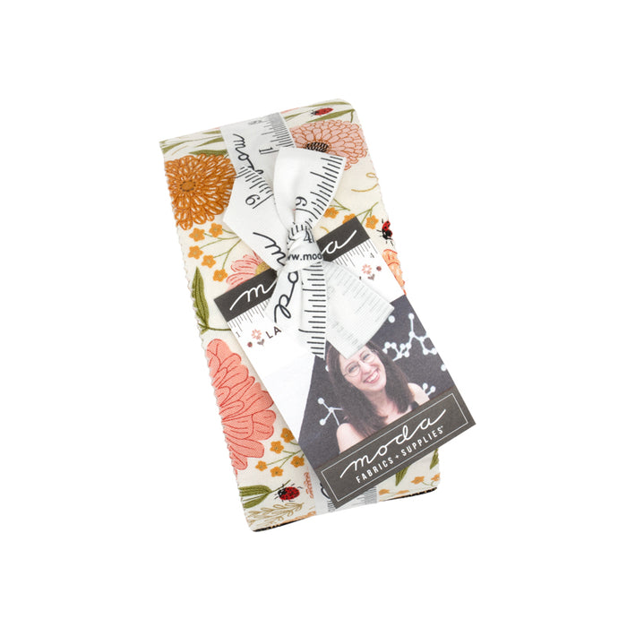 Packaged fabric roll with floral patterns and a photo of a person on a white background.
