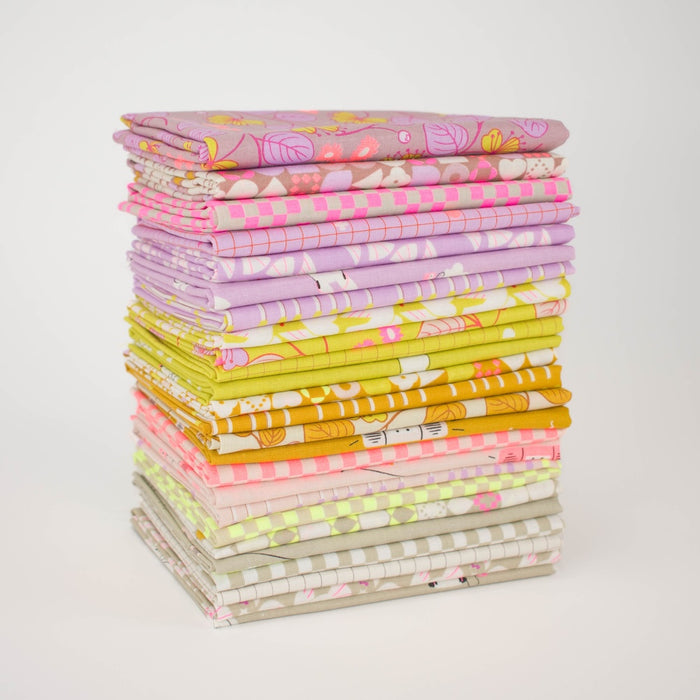 A stack of folded patterned fabric pieces in pastel and bright, neon colors, including pink, purple, yellow, & orange, arranged on a clean white background.