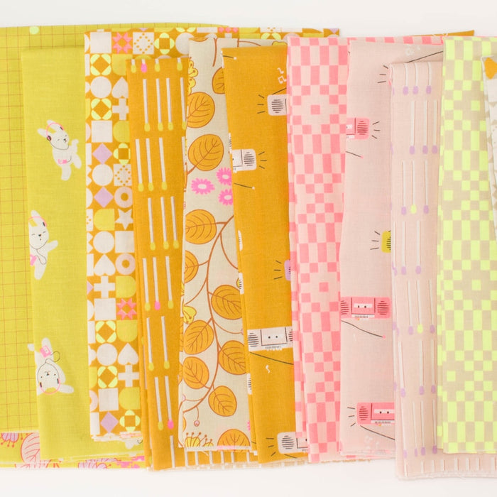 A fanned out line of ten patterned fabrics, including neon and pale pink, neon yellow, and orange, featuring various geometric, floral, and bunny motifs on a white background.