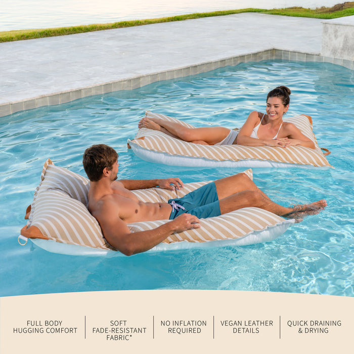 Two people relaxing on inflatable lounge chairs in a pool. #color_sand-stripe-sunbrella-fabric