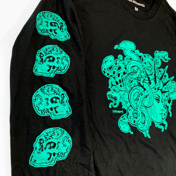 A black long-sleeve t-shirt featuring a large neon green graphic of Medusa on the chest and four matching skull prints down the left sleeve.