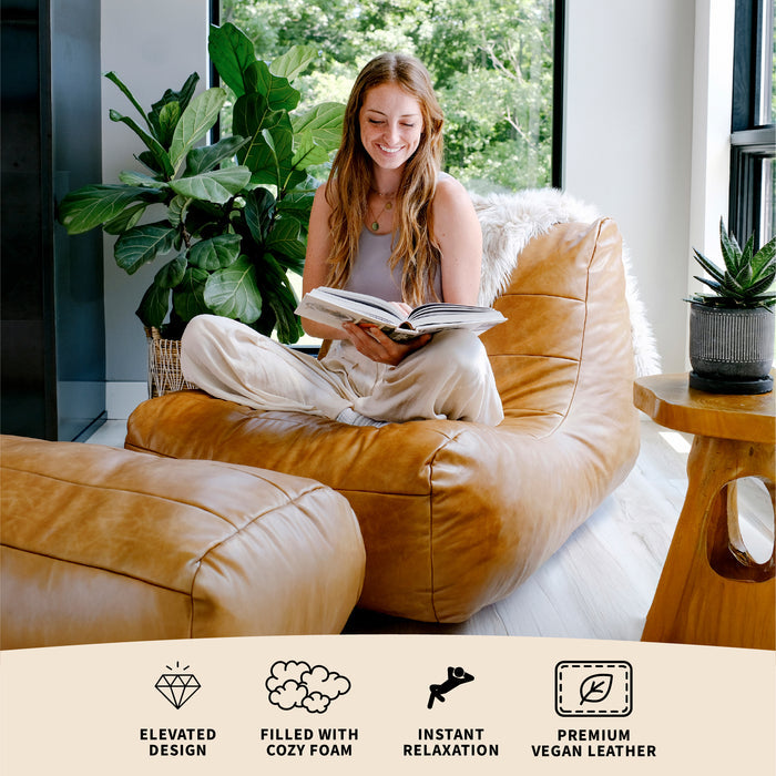 Woman reading a book on a brown bean bag chair in a bright room with plants. #color_copper-harbor-premium-vegan-leather
