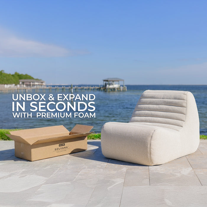 Chair and packaging on a patio with a scenic background #color_sunlit-cream-outdoor-performance-linen