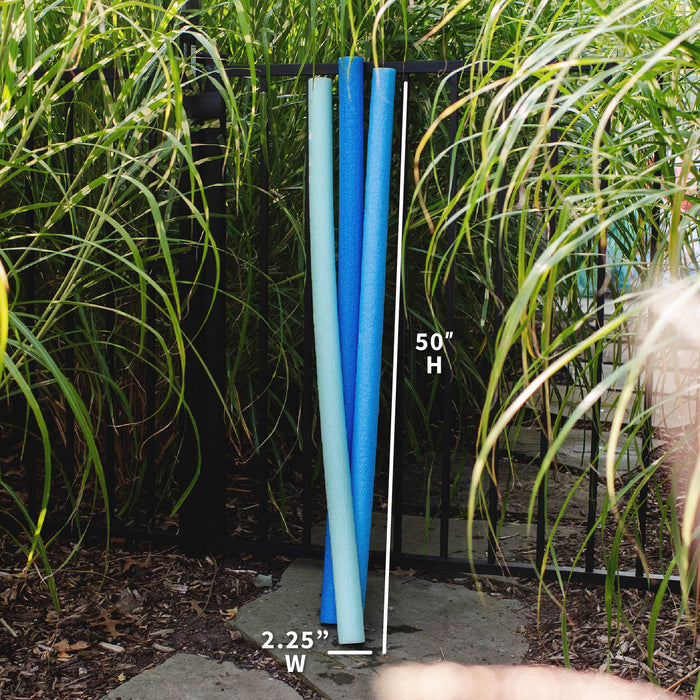 Three vertical pool noodles in light blue, medium blue, and navy are shown outdoors on a black metal rack, with white measurement lines and text indicating 50 inches high and 2.25 inches wide. #color_blues