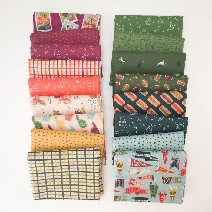 Two stacks of folded fabric with various sports-themed patterns including dog football players, plaids, stars, football play doodles, and tailgating dogs in reds, oranges, yellows, greens, blues, arranged side-by-side on a white background.