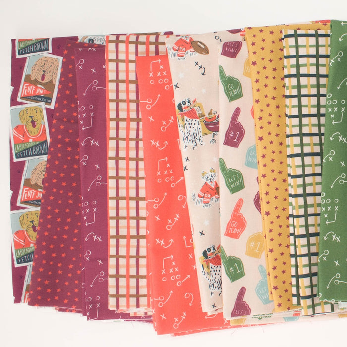 A fan of fabric samples with various sports-themed patterns including dog football players, plaids, stars, football play doodles, and tailgating dogs in reds, oranges, yellows, greens, on a white background.