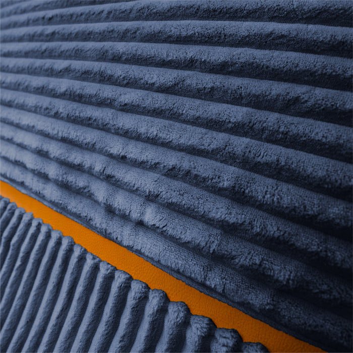Close-up of a ribbed corduroy fabric in dark blue-gray with a contrasting orange border. #color_midnight-blue-corded-plush