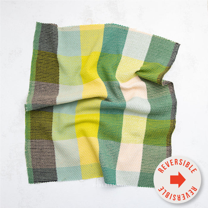 Folded checkered fabric with reversible label on a white background