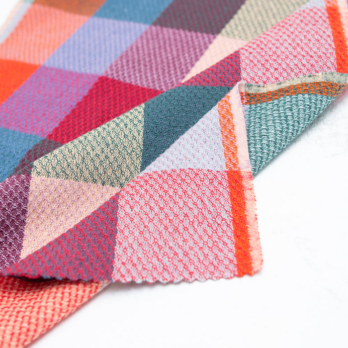 Colorful woven fabric with checkered pattern on a white background