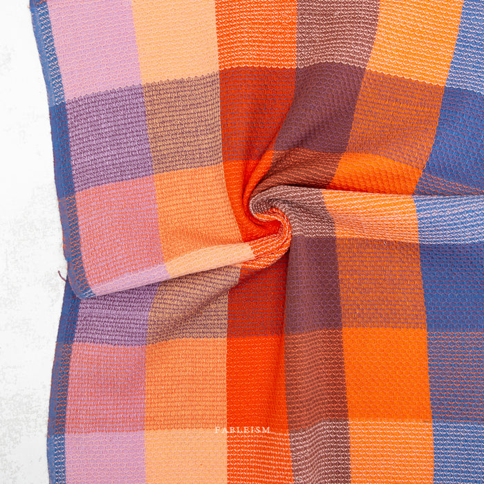 Close-up of a colorful checkered fabric with visible brand name, Fableism.