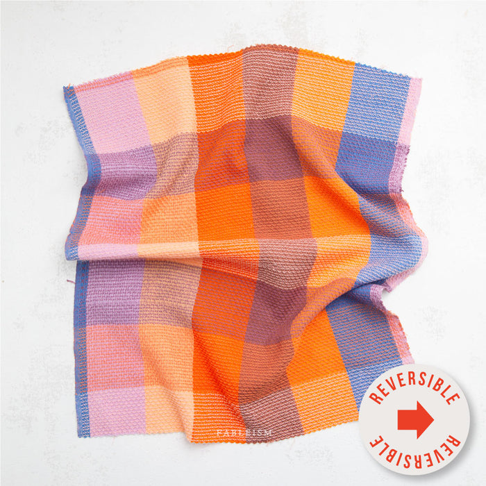 Colorful checkered fabric with a reversible label on a white background